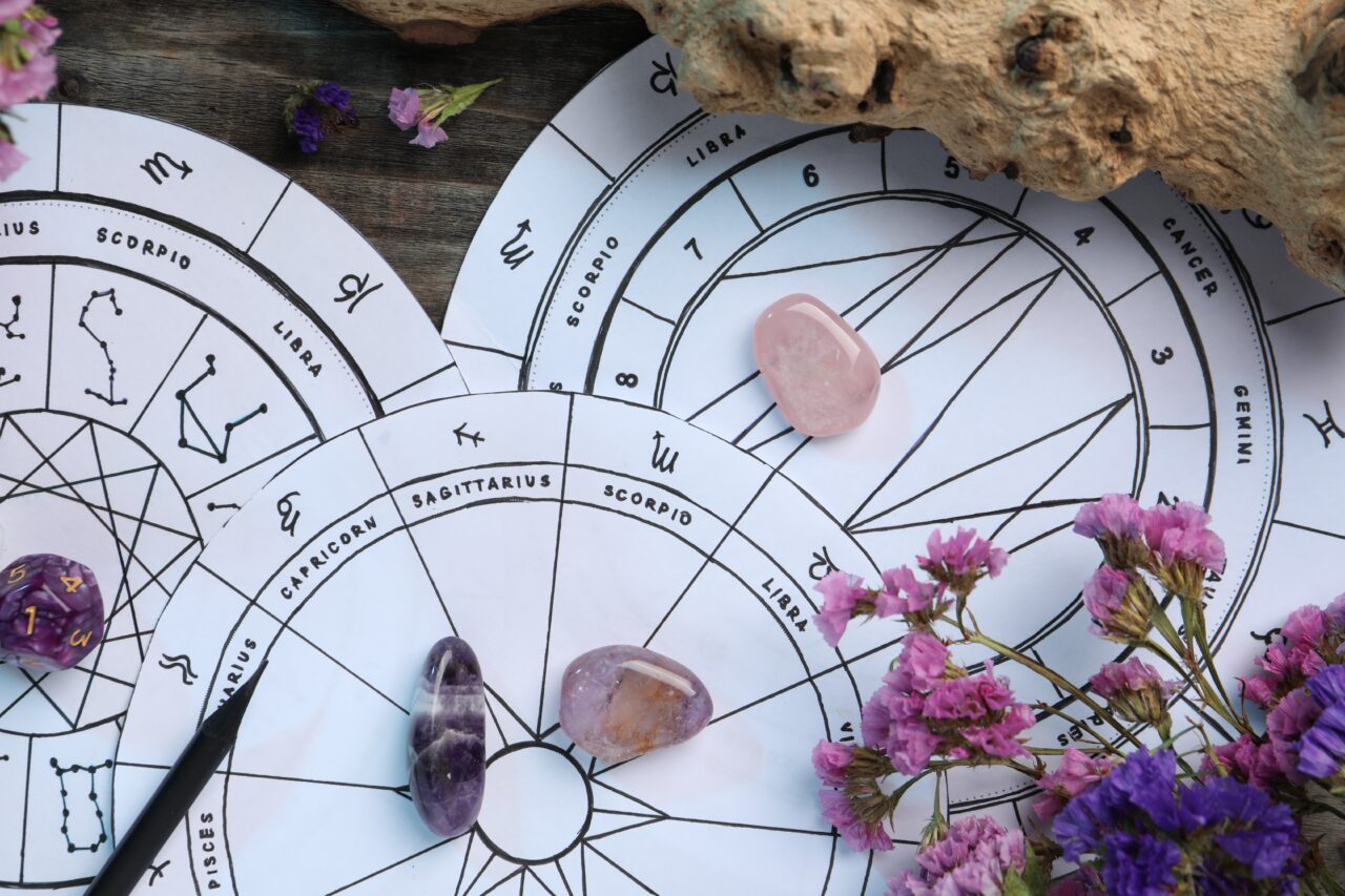 https://tiendastral.com/wp-content/uploads/2025/07/composicion-plana-con-ruedas-del-zodiaco-y-dados-de-astrologia-en-una-mesa-de-madera-1280x853.jpg